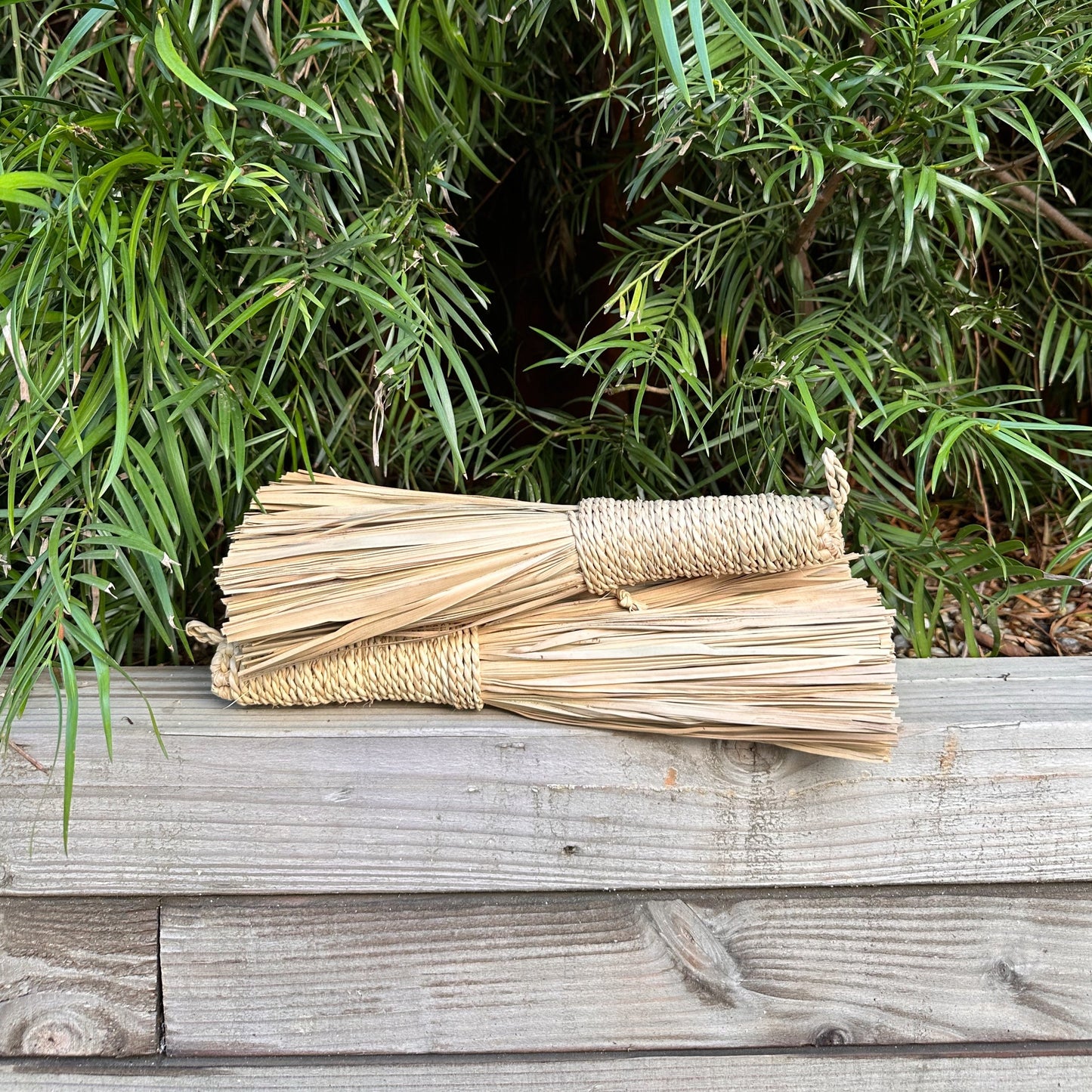 alt photo of hand brooms on planter ledge.